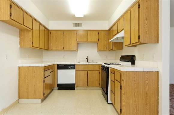 a kitchen with wooden cabinets and a stove and a sink