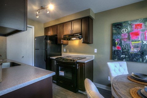 a kitchen with black appliances and a table