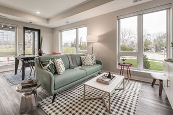 Furnished living room with large windows at at The Preserve at Normandale Lake in Bloomington, MN