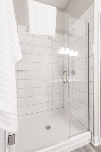 Walk in shower surrounded by grey rectangle tiles