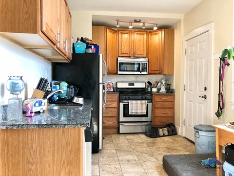 a kitchen with wooden cabinets and a black refrigerator