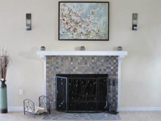 a living room with a fireplace and a painting on the wall