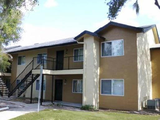 a yellow house with a balcony and a staircase