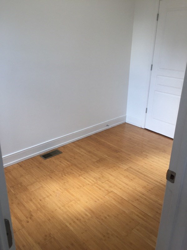 a room with a wooden floor and a white wall