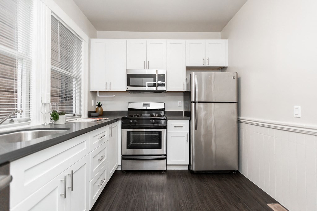 a kitchen with white cabinets and stainless steel appliances