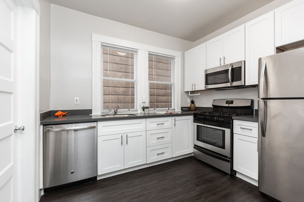 a kitchen with stainless steel appliances and white cabinets