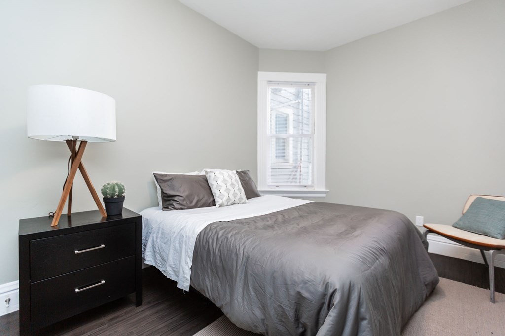 a bedroom with a bed and a dresser and a window