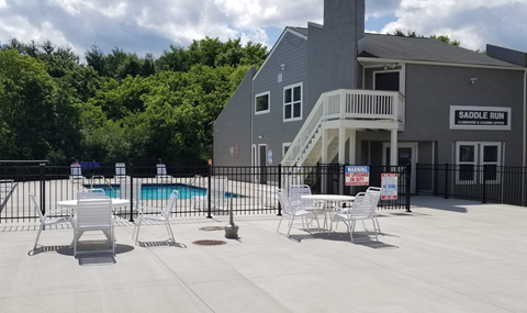our apartments have a large pool and patio with chairs and tables