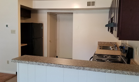 a kitchen with a counter and a stove and a refrigerator