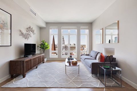 a living room with a couch and a tv and a window