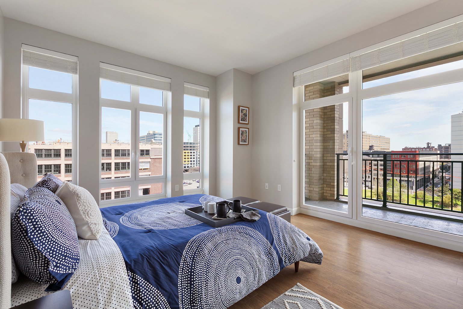 a bedroom with a large bed and a view of the city