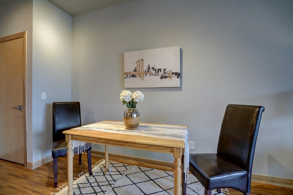 a dining room with a wooden table and two black chairs
