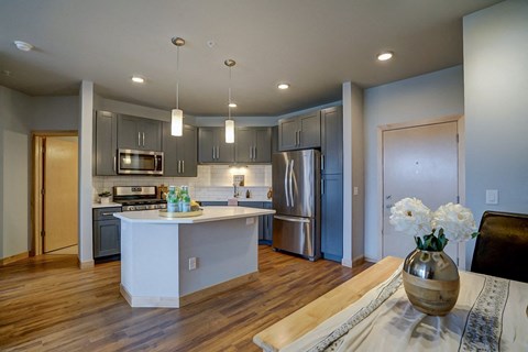 a kitchen with a center island and a stainless steel refrigerator