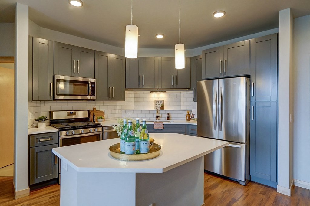 a kitchen with stainless steel appliances and gray cabinets