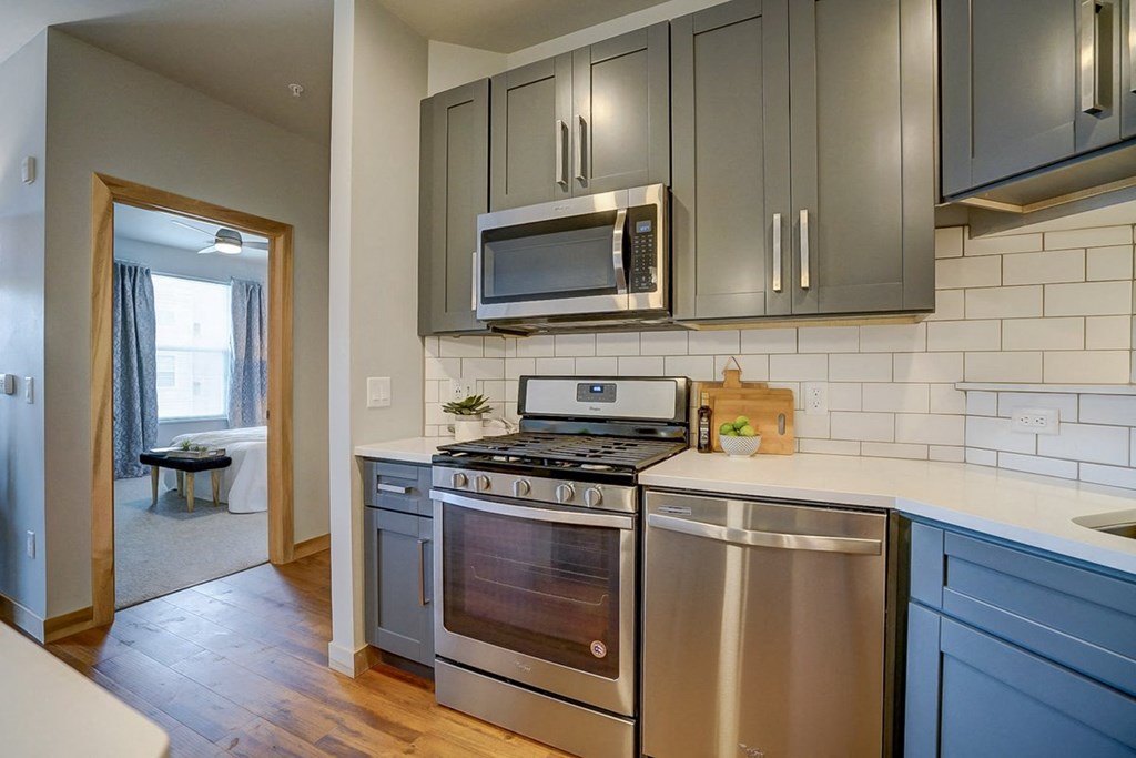 a kitchen with stainless steel appliances and gray cabinets