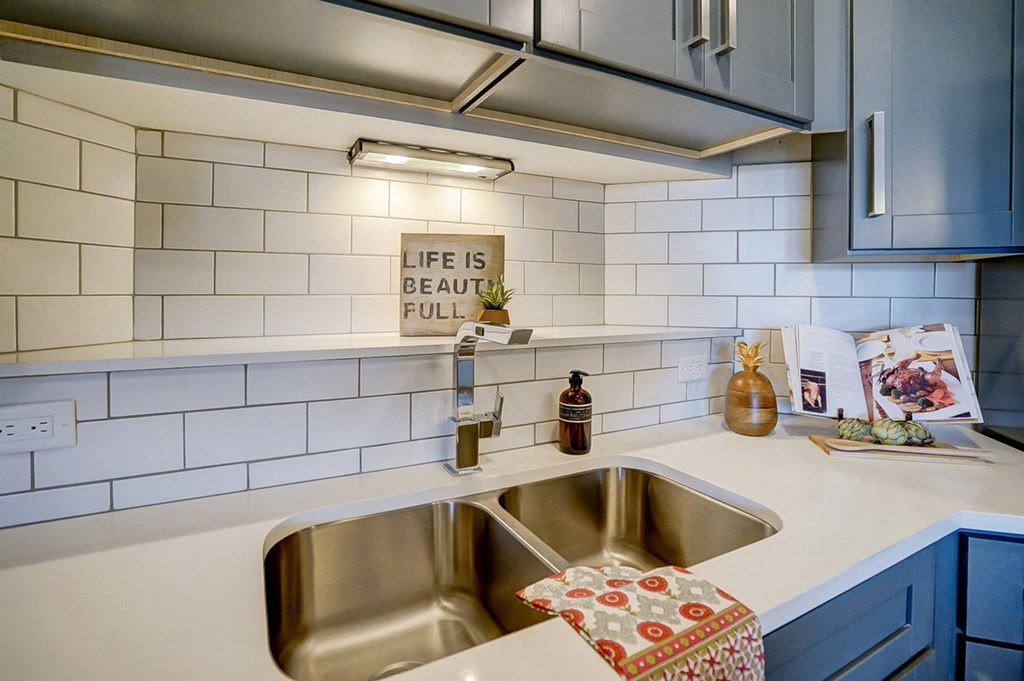 a kitchen with a sink and a sign on the wall