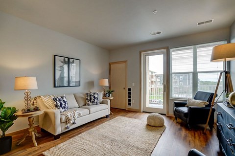 a living room with a couch and a door to a balcony