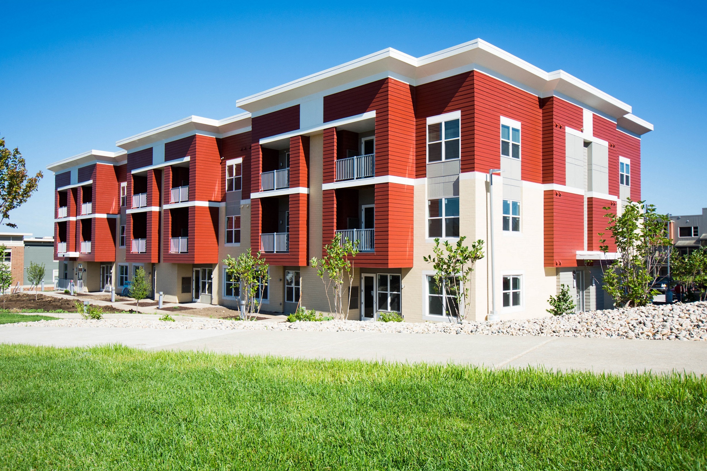 a modern apartment building with red and white exterior
