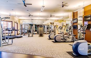 Expansive Fitness Center with Interactive TV Monitors Overlooking The Pool