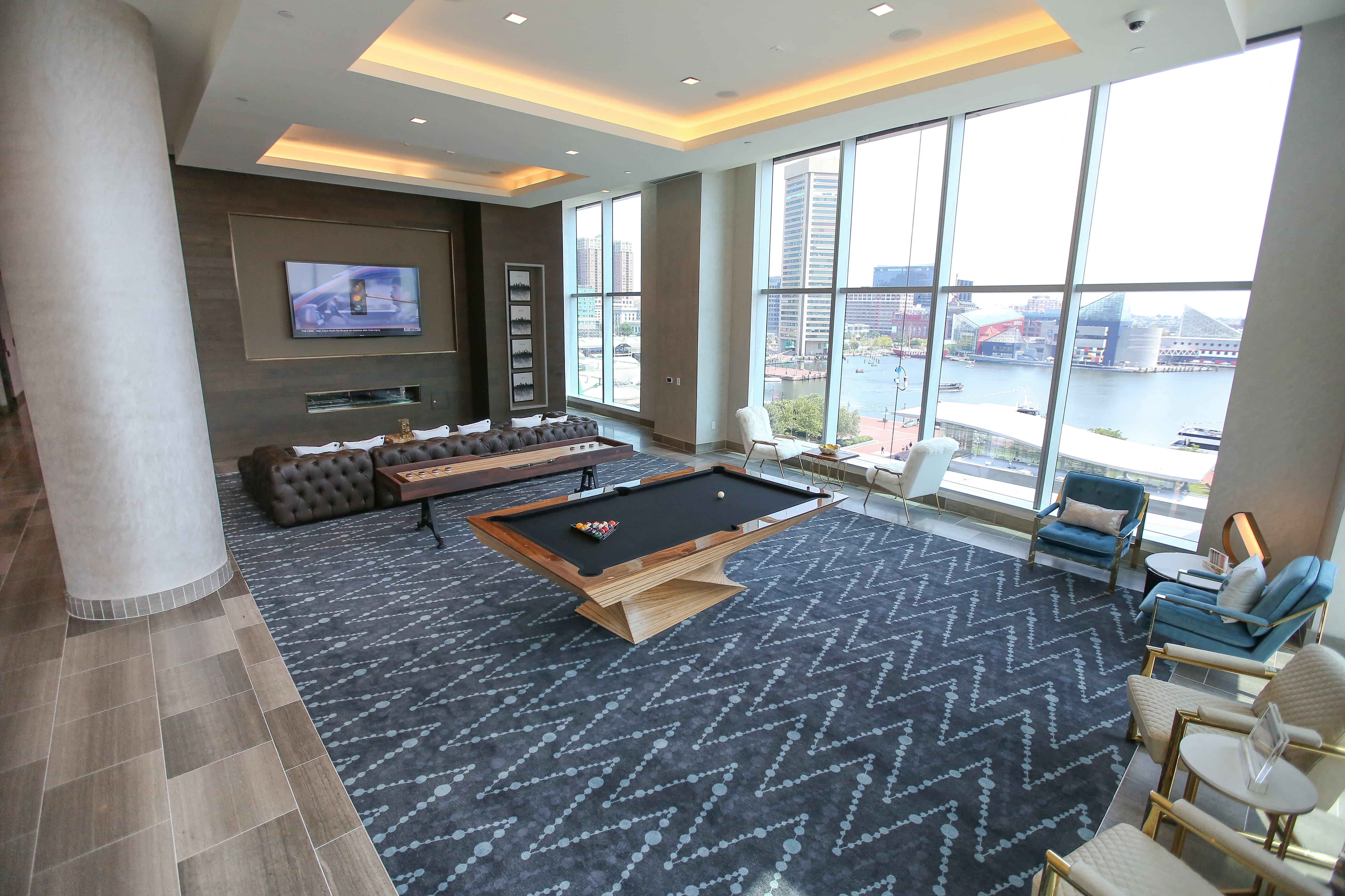 a large living room with a pool table and large windows