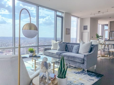 a living room with a gray couch and a view of the city from the window