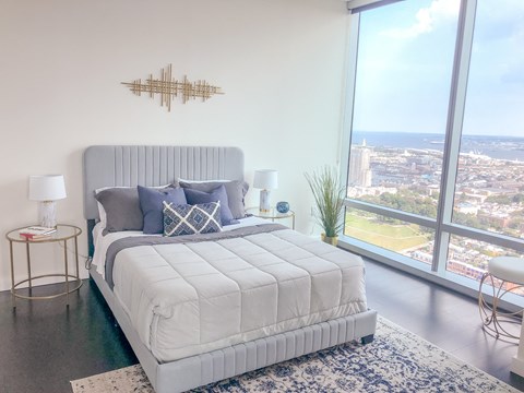 a bedroom with a bed and a view of the city