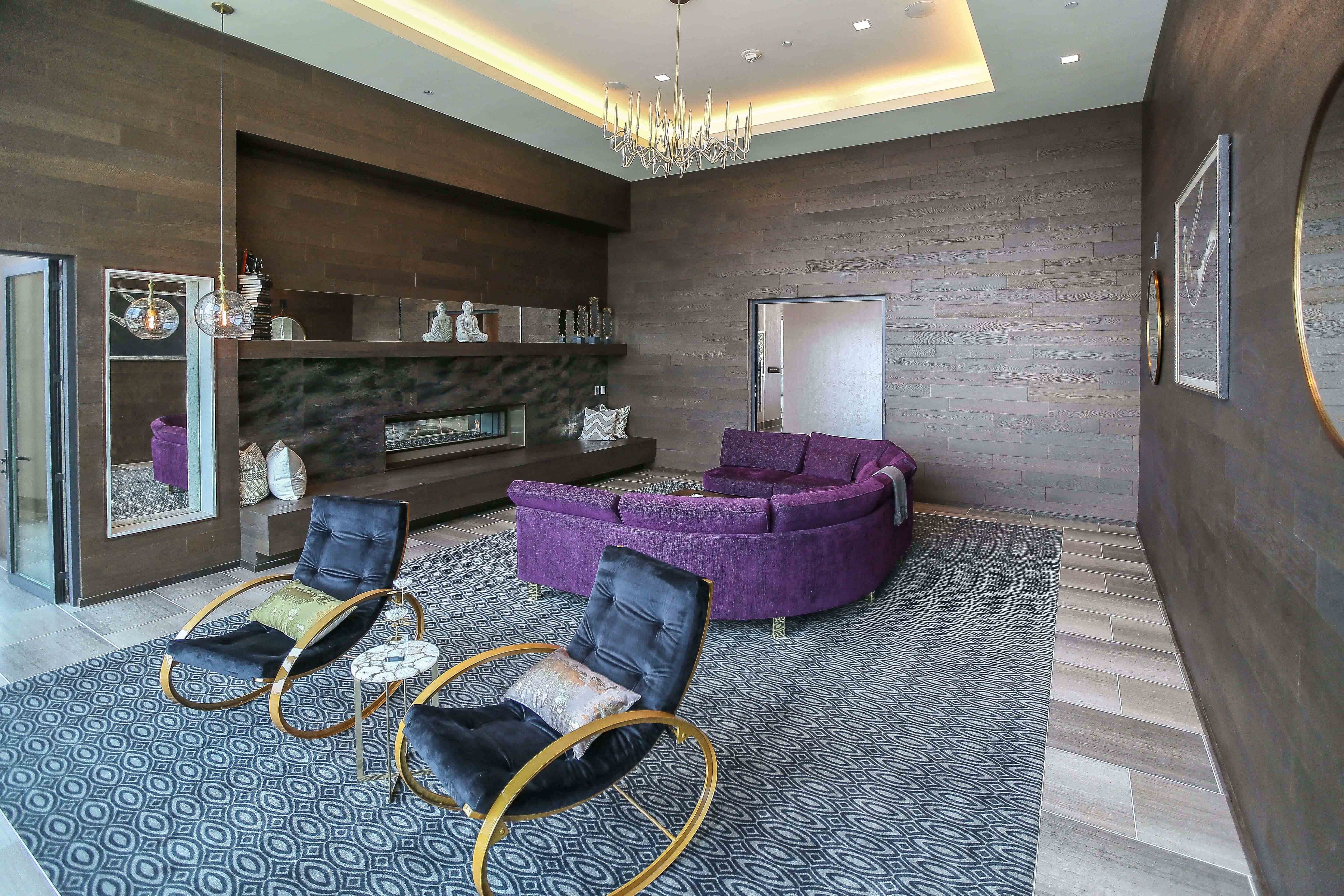 a living room with a purple couch and two chairs