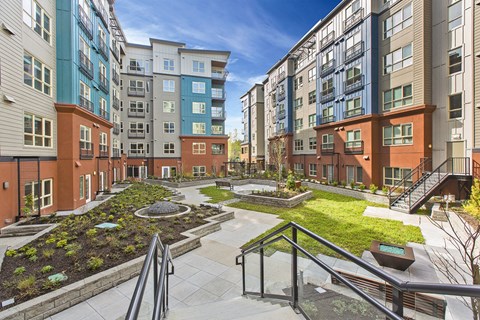 A view of a courtyard with a staircase and a railing.
