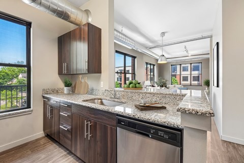A modern kitchen with a stainless steel dishwasher and wooden cabinets.