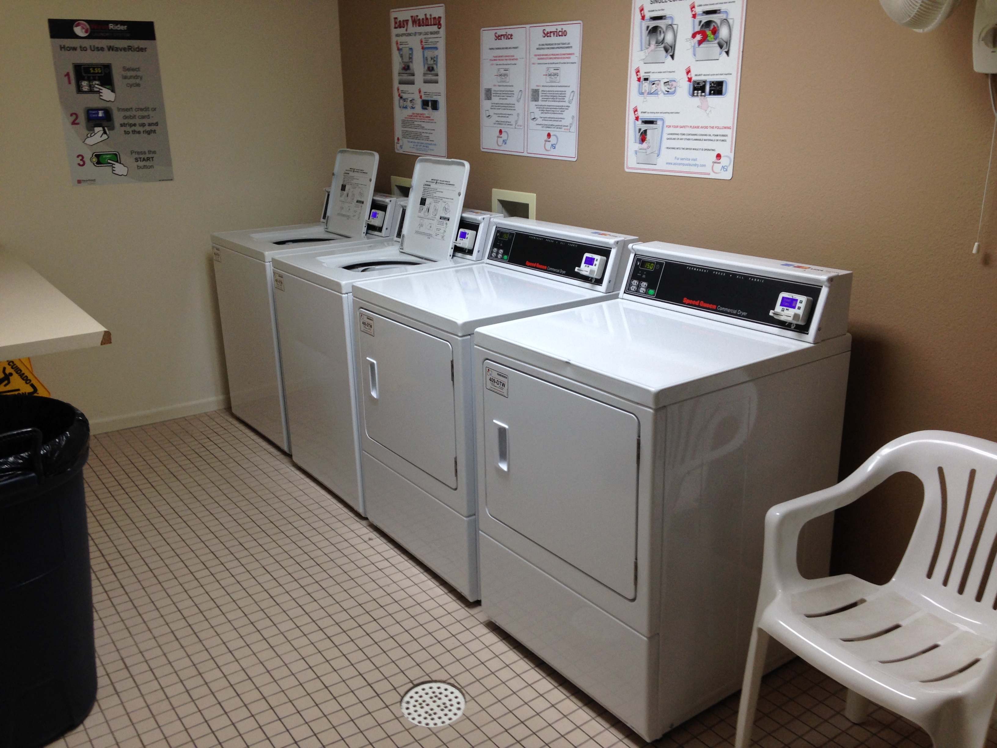a row of washers and dryers in a laundry room