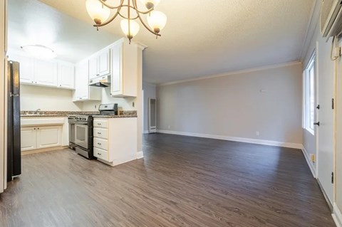 A kitchen with white cabinets and a black refrigerator.
