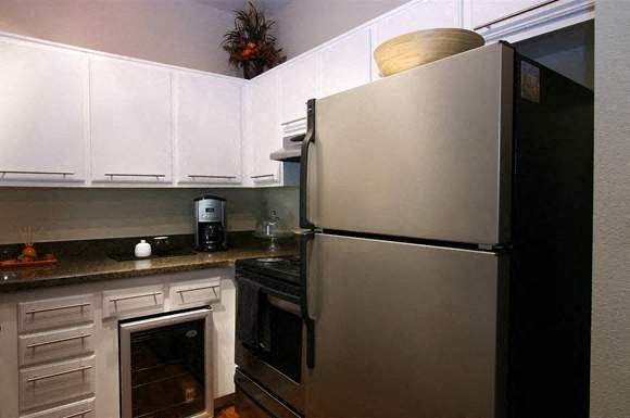 a kitchen with a stainless steel refrigerator and a stove