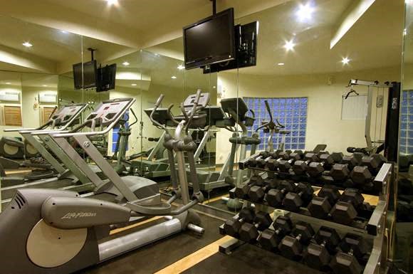 a gym with a lot of weights and a tv