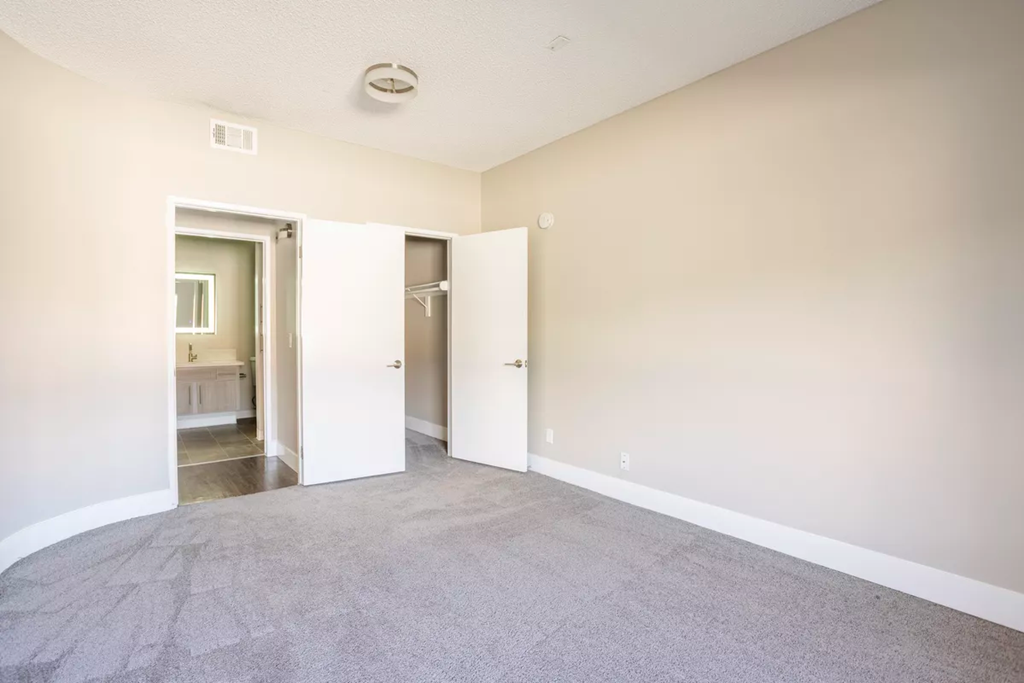 an empty living room with white walls and carpet