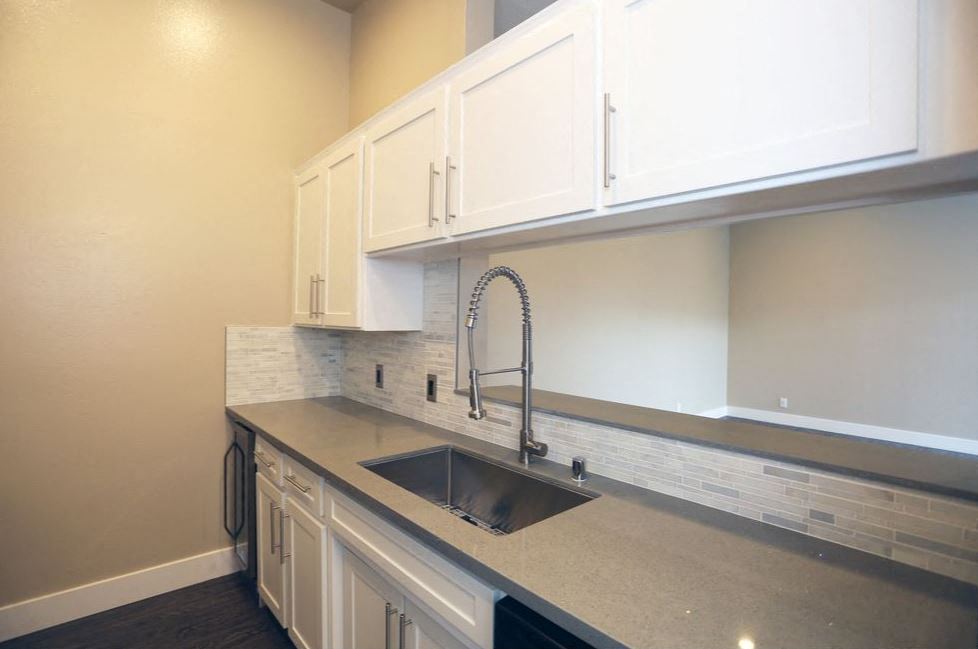 a kitchen with a sink and white cabinets