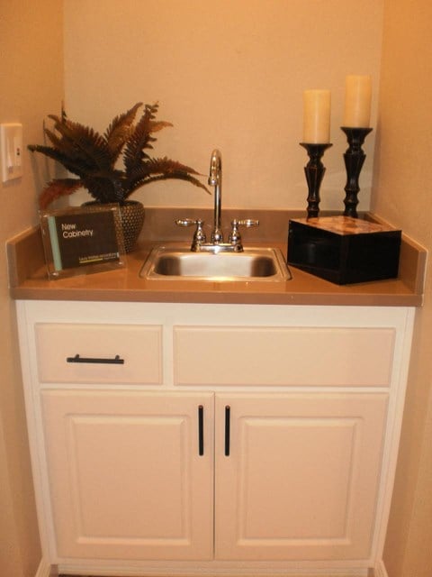 a kitchen sink with a counter top and cabinets