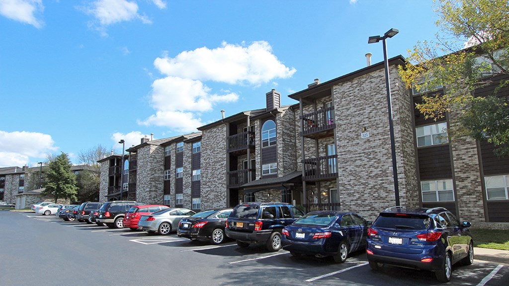 a parking lot full of cars in front of a building