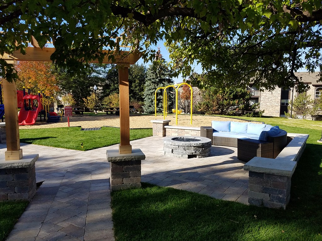 a patio with a fire pit and a playground