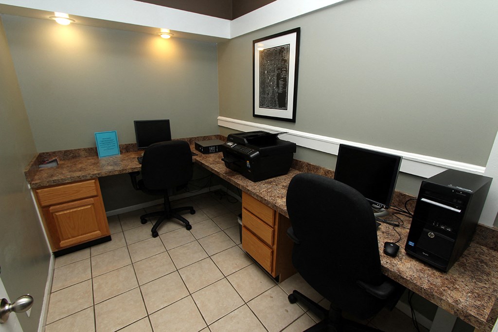 a home office with two desks and two computer monitors