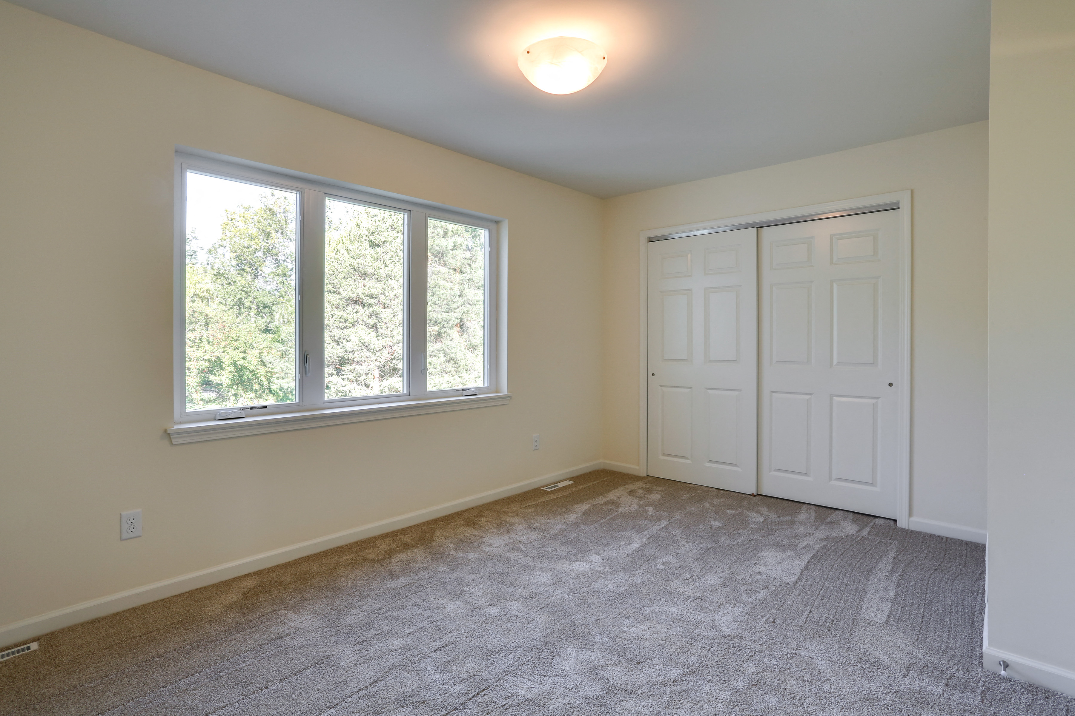 an empty living room with a large window and a door
