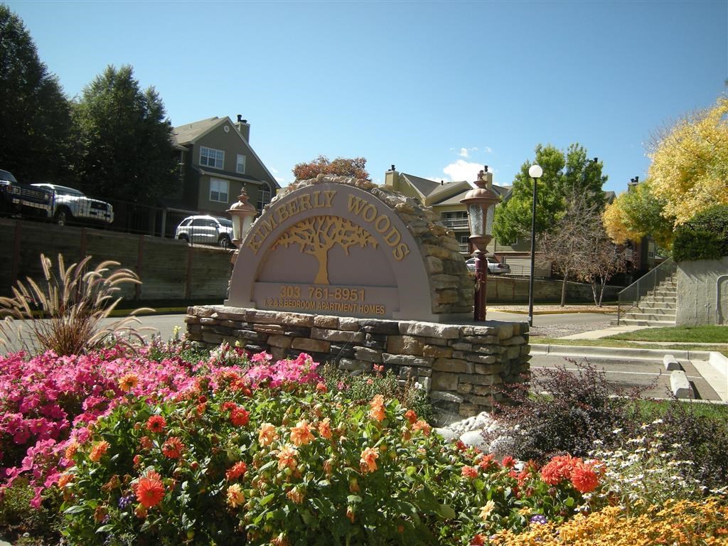 the sign is in front of a park with flowers