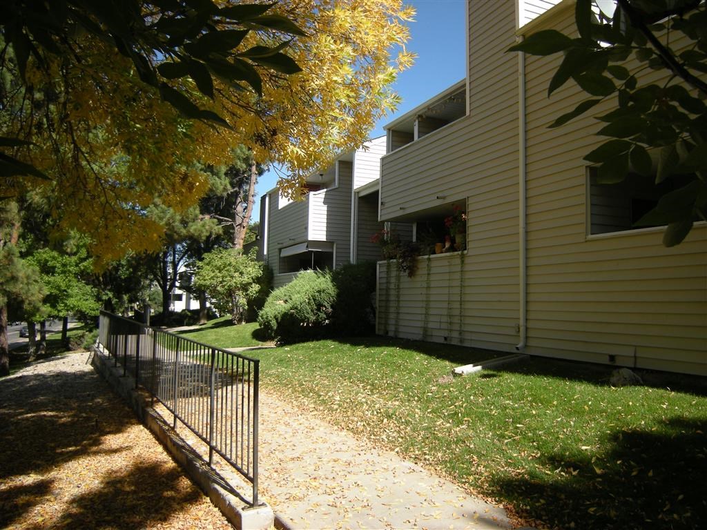 the side of a house with a yard and a fence
