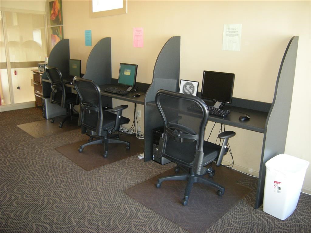 a group of desks with computers and chairs in a room