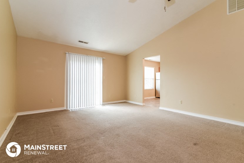 the spacious living room and dining room of an apartment