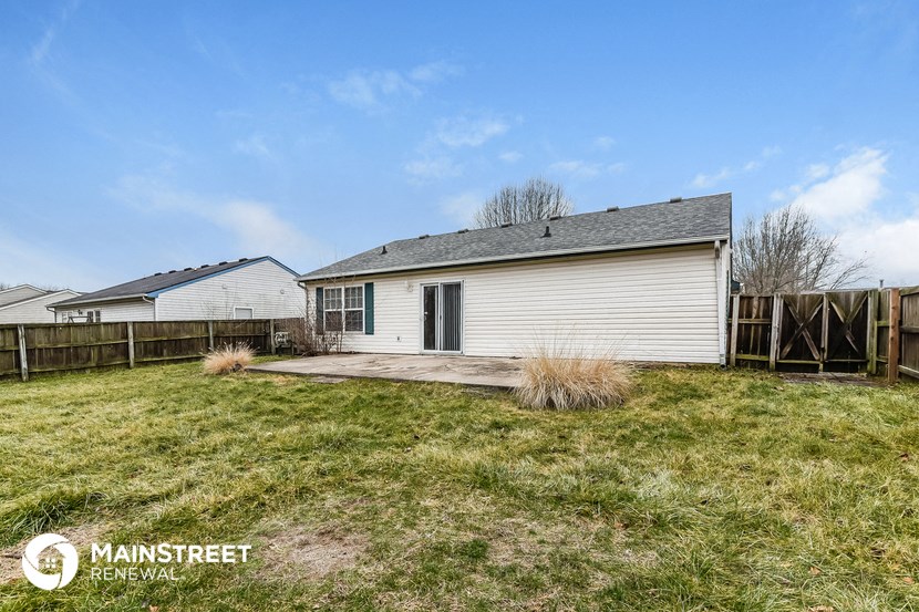 a small white house with a yard and a fence