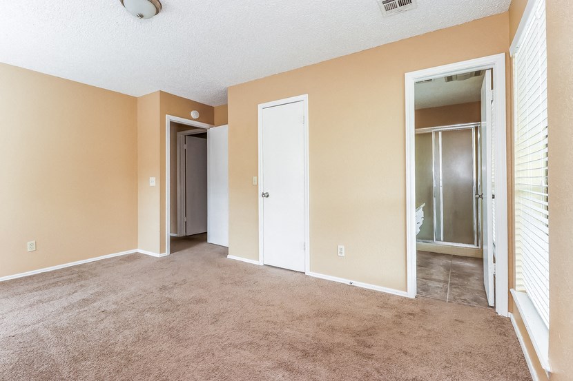 an empty living room with a door to a closet
