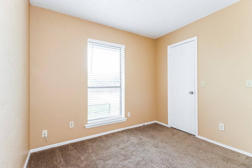 a room with carpet and a window and a door