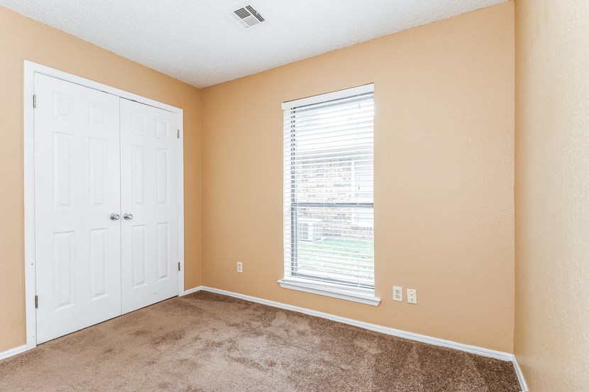 an empty room with a window and a white door