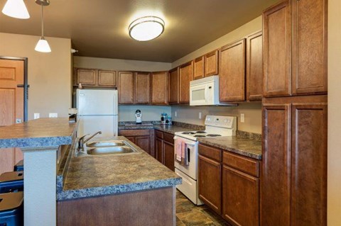 a kitchen with wooden cabinets and white appliances