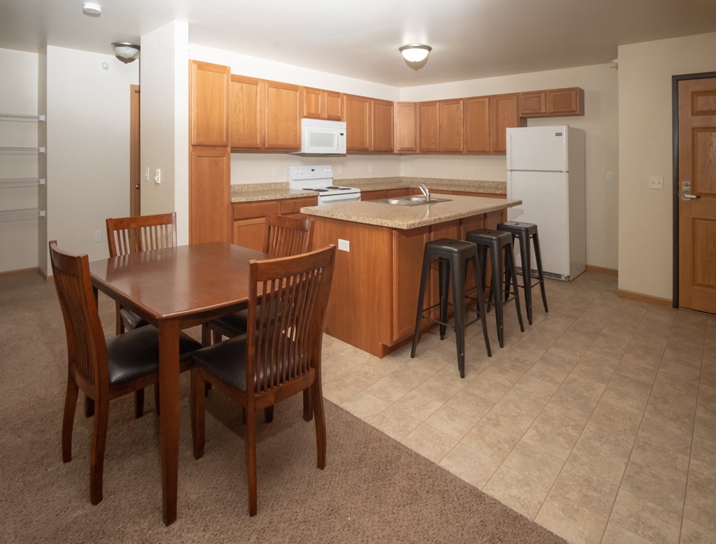 a kitchen with a dining area and a table with chairs